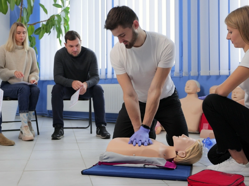 Man performing CPR on a dummy.